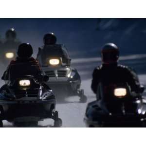 Snowmobilers Ride Down a Snowy Road in Yellowstone Park Photographic 